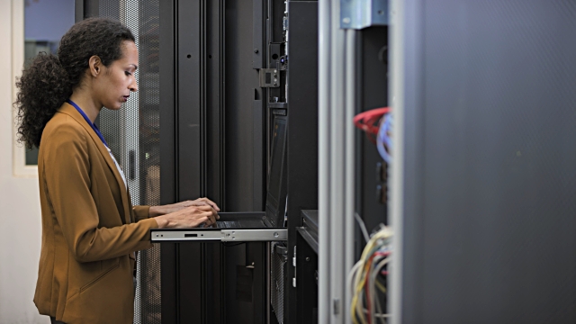 639074652-640x640 Medium locked down shot of a female technician analyzing server functions in the server room using a laptop.